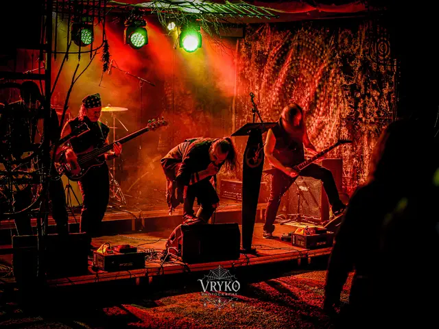 Full band on the outdoor stage in red haze, vocalist bent over the mic
